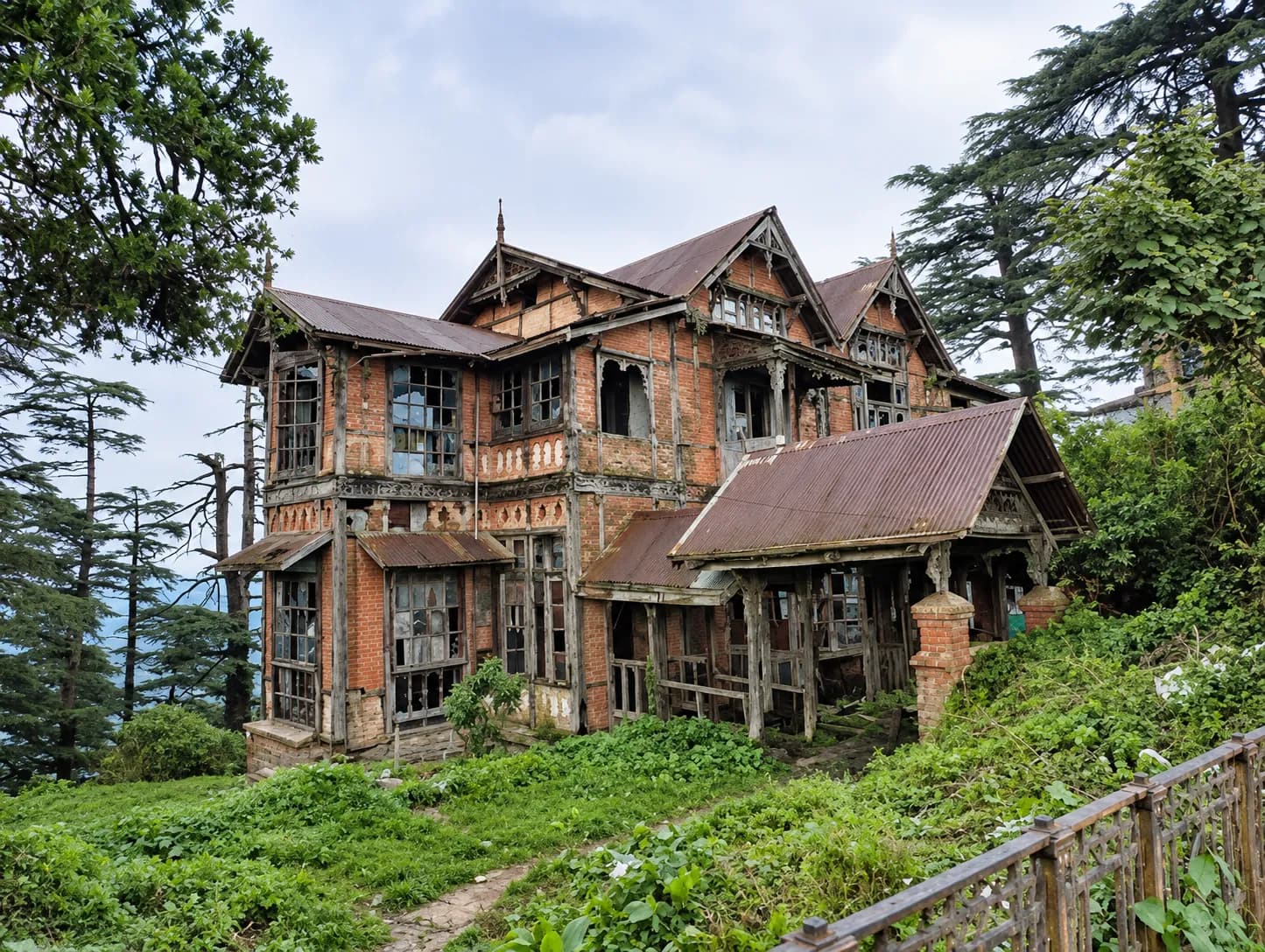 A decaying, abandoned colonial-era mansion among deodar pines, evoking the haunted heritage sites of the Himalayan hill stations