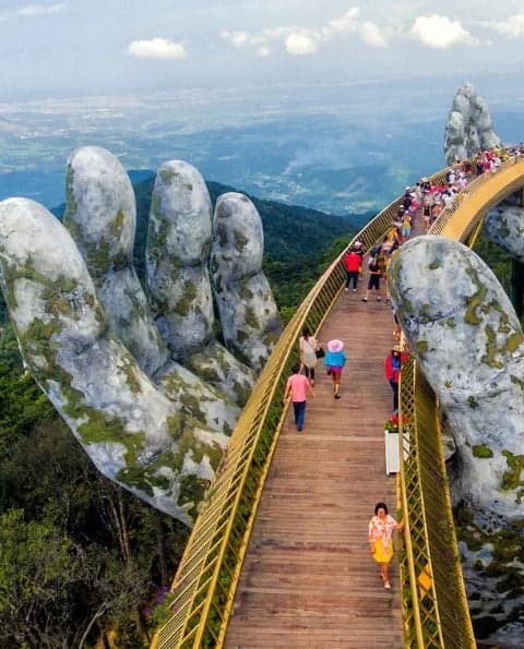 The Golden Bridge held by giant stone hands at Ba Na Hills, Da Nang, Vietnam