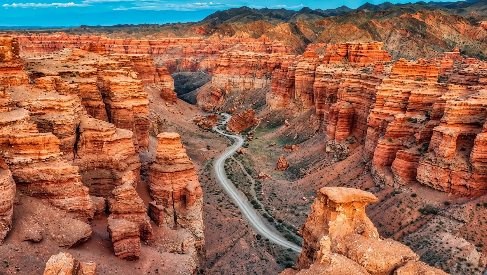The red-rock formations of Charyn Canyon in Kazakhstan, with a road winding through the valley floor