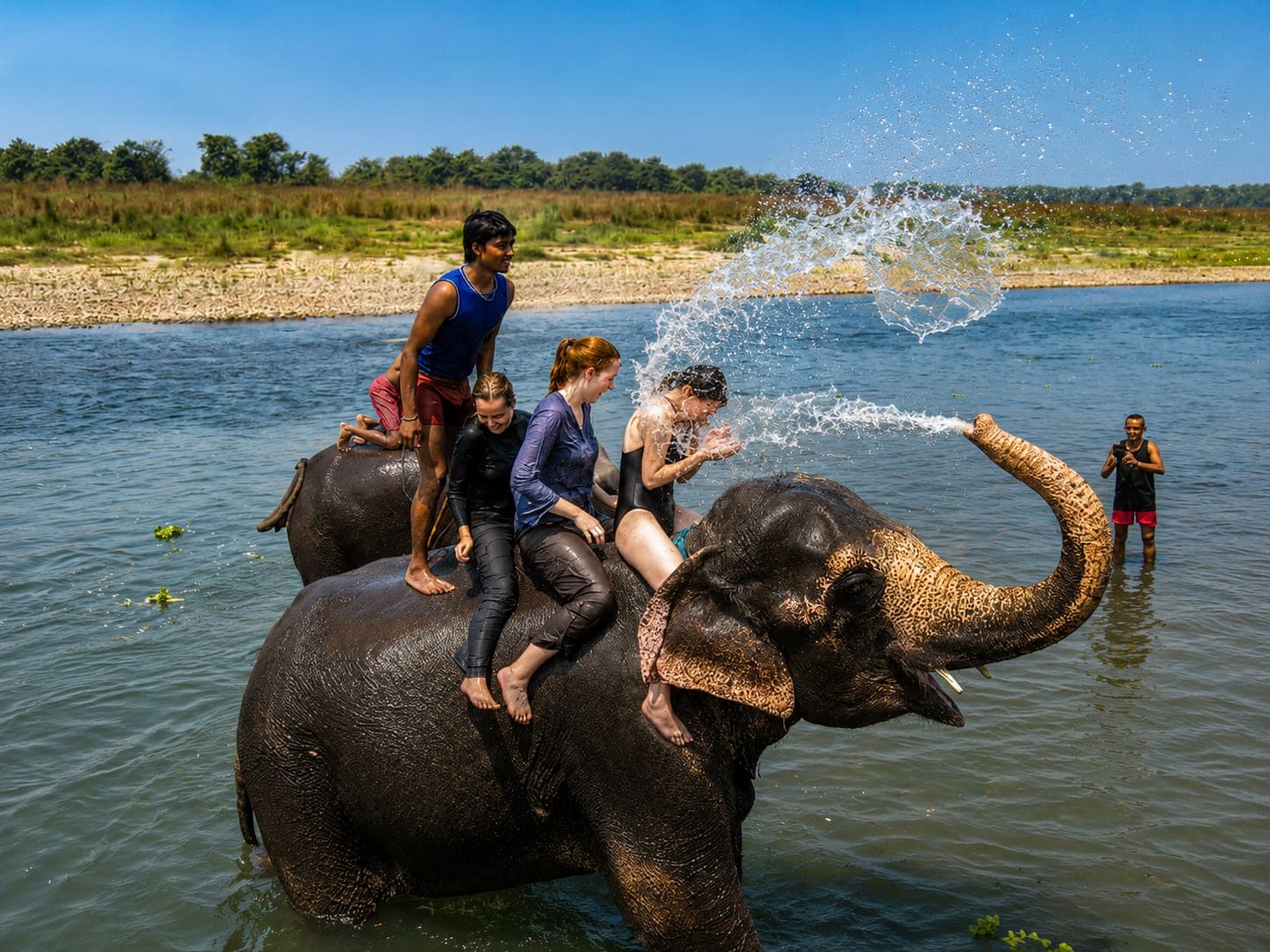 Elephant bathing with tourists on the river in Chitwan