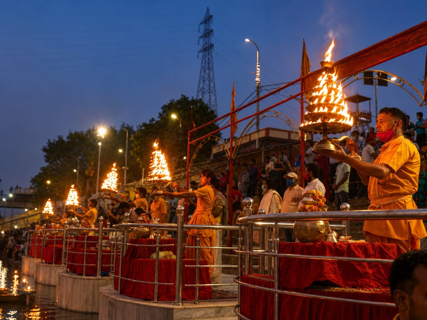 Priests performing the evening Ganga Aarti with flame lamps