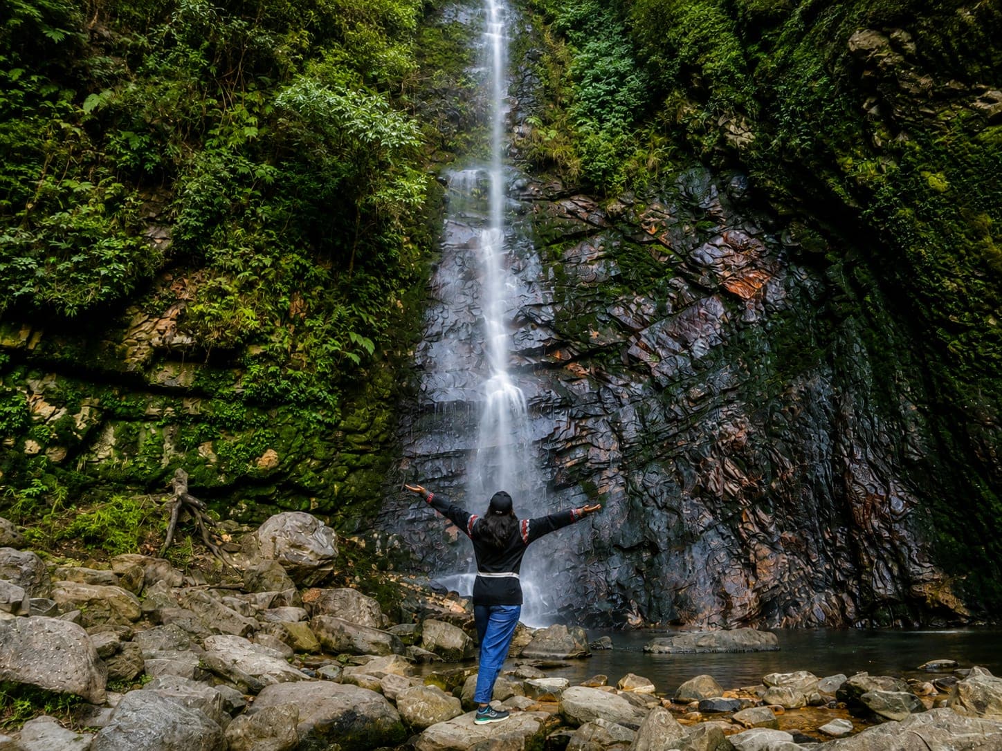A trekker at the base of Choi Waterfall